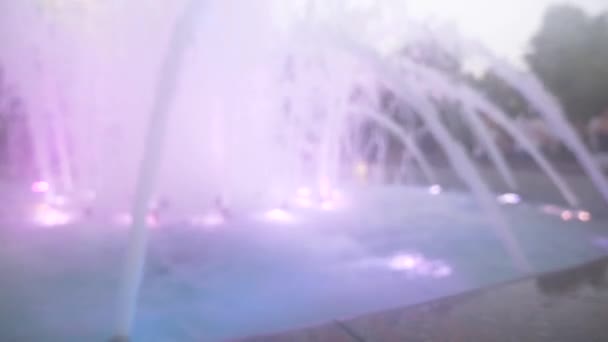 Una fontana con illuminazione ad acqua colorata, la sera. primo piano, sfocatura, 4k — Video Stock