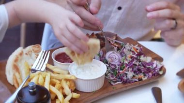 4k, yakın çekim. Baba ve küçük kızı lokanta fast food restoran terasında yemek.