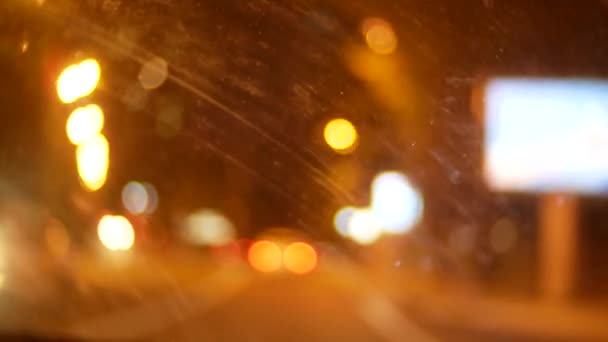 Coche ventana noche fondo desenfoque en movimiento, a través de la ventana sucia del coche, manchas de suciedad marchitas después de la lluvia. 4k — Vídeo de stock