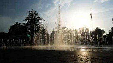 Çocuk siluetleri bir yaz günü kentin fıskiyede oynamak. 4k.