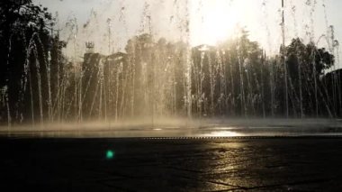 Çocuk siluetleri bir yaz günü kentin fıskiyede oynamak. 4k.