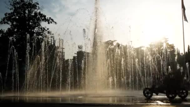 Dětské siluety hrají v citys fontána v letním dni. 4k. — Stock video