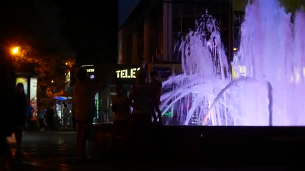 Una fuente con iluminación de agua de colores, por la noche. primer plano, desenfoque, 4k — Vídeo de stock
