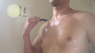 yakışıklı bir genç adam banyoda sabah göğüsler onun shaves. Penceresinden güneşin ışınları tarafından yaktı. 4 k, ağır çekim, yakın çekim