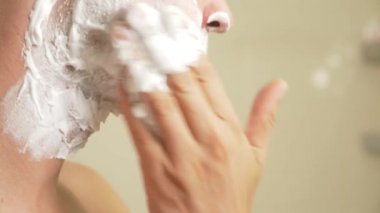 yakın çekim. yakışıklı adam yüzünü tıraş. 4k, ağır çekim