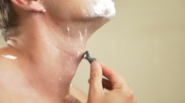 yakın çekim. yakışıklı adam yüzünü tıraş. 4k, ağır çekim