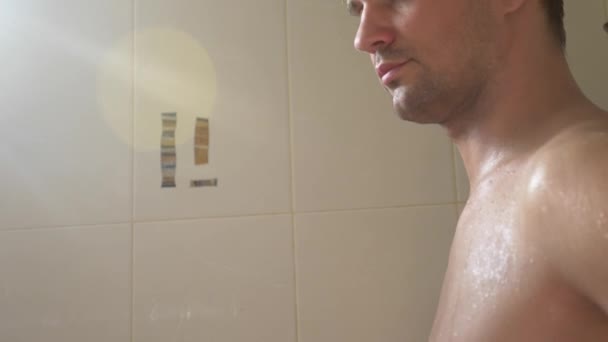 Przystojny Młody Mężczyzna Biorąc Prysznic Łazience Świeci Się Przez Promienie — Wideo stockowe