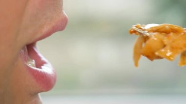 yakın çekim. profil erkek dudaklarında. adam kırmızı soslu spagetti yiyor. 4k, ağır çekim.