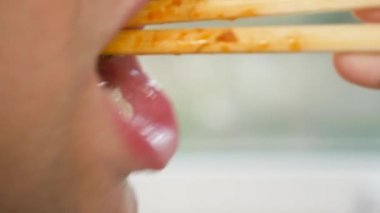 yakın çekim. profil erkek dudaklarında. yemek çubukları, 4 k, ağır çekim adam yiyor.