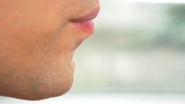 yakın çekim. profil erkek dudaklarında. bir adam yemek çubukları, otlar ile taze salatalık salatası yiyor. 4k, ağır çekim.