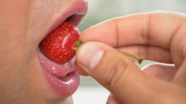 yakın çekim. profil erkek dudaklarında. seksi erkek dudakları çilek yiyin. 4k, ağır çekim.
