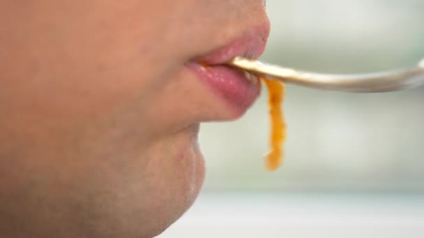 特写。男性嘴唇在外形。这个人正在吃意大利面加红酱。4k. 慢动作. — 图库视频影像