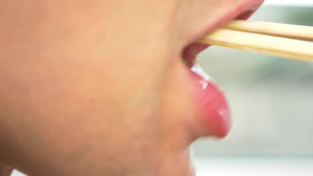 클로즈업입니다. 프로필에 남성 입술입니다. 남자는 젓가락 나물과 신선한 오이 샐러드를 먹는다. 4 k, 슬로우 모션. — 비디오