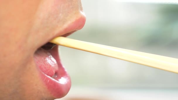 Close-up. lábios masculinos em perfil. As pessoas comem pauzinhos, azeitonas e azeitonas. 4k, câmera lenta . — Vídeo de Stock