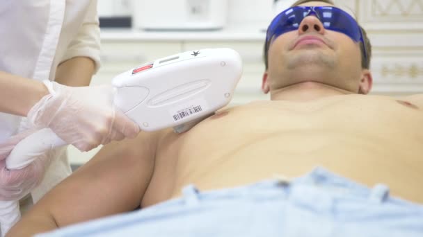 Depilazione laser maschile. un medico in guanti bianchi rimuove i capelli dall'addome e dal seno di un uomo. 4k, primo piano. Rallentatore — Video Stock