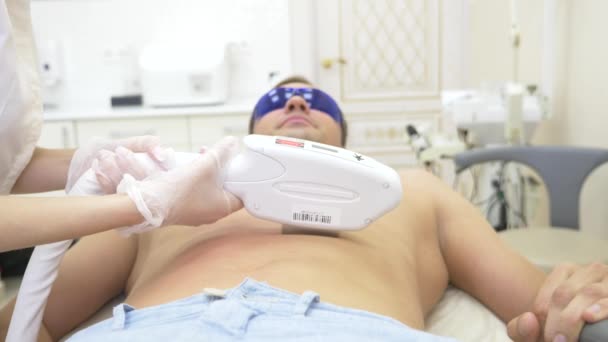 Épilation laser masculine. un médecin en gants blancs enlève les poils de l'abdomen et des seins d'un homme. 4k, gros plan. Mouvement lent — Video