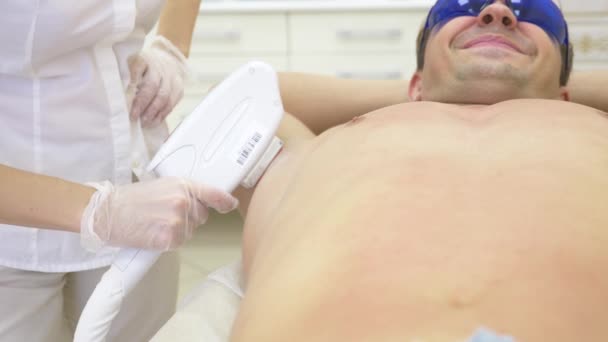 Depilacja laserowa mężczyzna. lekarz w białe rękawiczki usuwa włosy z brzucha i piersi człowieka. 4k, szczegół. Zwolnionym tempie — Wideo stockowe