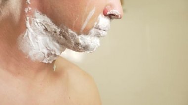 yakın çekim. yakışıklı adam yüzünü tıraş. 4k, ağır çekim