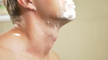 yakın çekim. yakışıklı adam yüzünü tıraş. 4k, ağır çekim