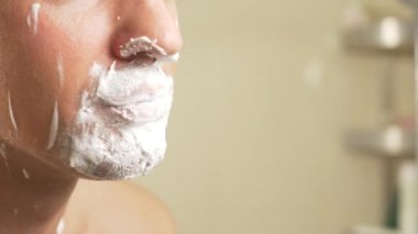 yakın çekim. yakışıklı adam yüzünü tıraş. 4k, ağır çekim