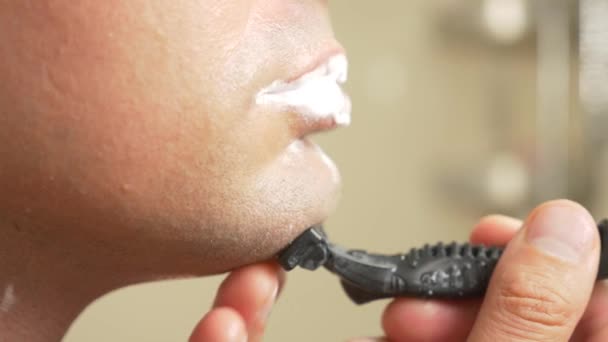 Nahaufnahme. schöner Mann rasiert sich das Gesicht. 4k, Zeitlupe — Stockvideo