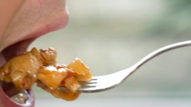 yakın çekim. profil erkek dudaklarında. adam kırmızı soslu spagetti yiyor. 4k, ağır çekim.