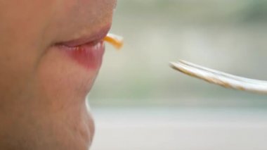 yakın çekim. profil erkek dudaklarında. adam kırmızı soslu spagetti yiyor. 4k, ağır çekim.