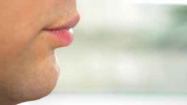 yakın çekim. profil erkek dudaklarında. bir adam bir çatalla et yer. 4k, ağır çekim.