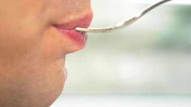 yakın çekim. profil erkek dudaklarında. bir adam bir çatalla et yer. 4k, ağır çekim.