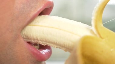 yakın çekim. profil erkek dudaklarında. seksi erkek dudakları bir muz yemek. 4k, ağır çekim