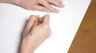 Ağır çekim. 4k, yakın çekim, en iyi görünüm. bir el bir kalemle çizer. bir kız elbise.