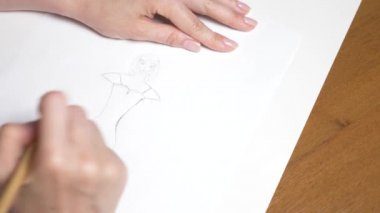 Ağır çekim. 4k, yakın çekim, en iyi görünüm. bir el bir kalemle çizer. bir kız elbise.