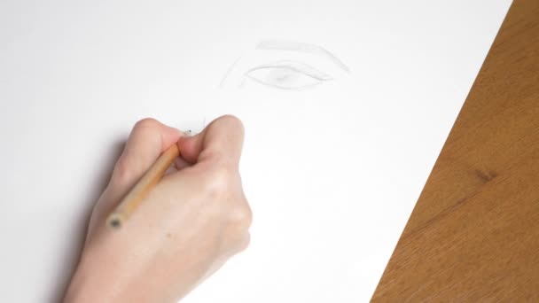 une main féminine dessine le portrait d'une fille. 4k, gros plan. Au ralenti. vue d'en haut .