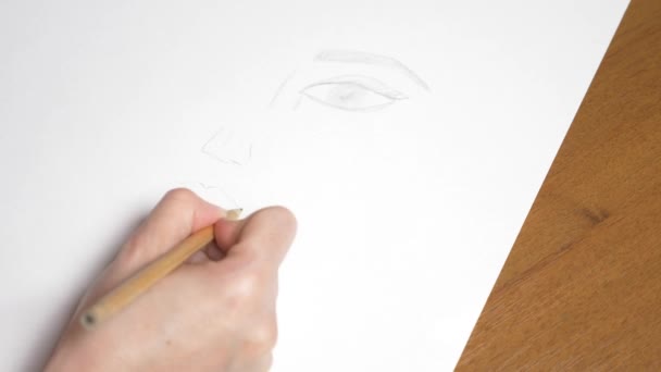 une main féminine dessine le portrait d'une fille. 4k, gros plan. Au ralenti. vue d'en haut 