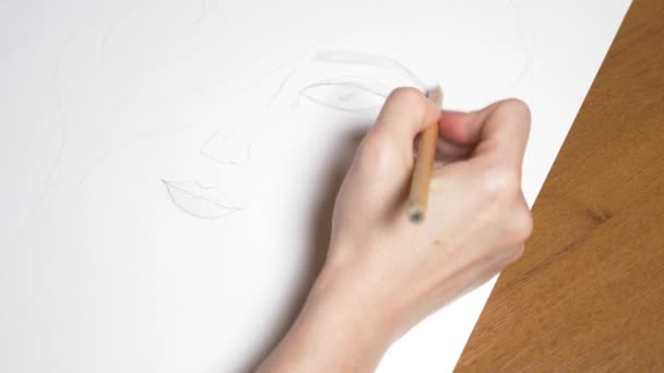 une main féminine dessine le portrait d'une fille. 4k, gros plan. Au ralenti. vue d'en haut .