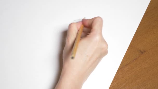 une main féminine dessine le portrait d'une fille. 4k, gros plan. time-lapse. vue d'en haut .