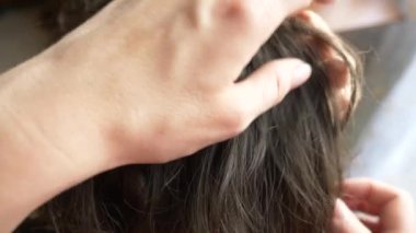 Yakın çekim. 4k, ağır çekim. Eller, üzerinde kahverengi saçlı kafa bitleri bulmak. pediculosis tedavisinde.