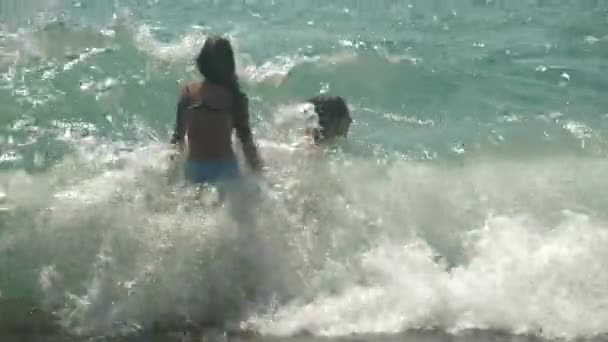 Enfants heureux sautent dans les vagues de la mer. 4k, au ralenti . — Video