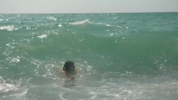 Šťastné děti skáčí do mořských vln. 4k, pomalý pohyb. — Stock video