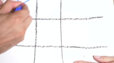 Hızlandırılmış. 4k, yakın çekim, en iyi görünüm. Tic Tac Toe ile kırmızı kalem mavi. Erkek ve kadın eli. bir erkek ve bir kadın arasındaki rekabet kavramı.