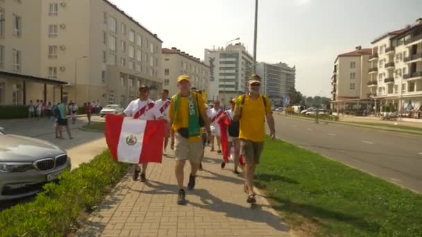 SOCHI, ADLER, RUSIA 26 de junio de 2018: FIFA 2018. Los aficionados al fútbol de la selección nacional de Perú y Australia van al partido en el estadio Fisht en el pueblo olímpico. 4K, EDITORIAL — Vídeo de stock