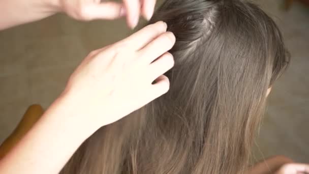 Крупним планом. 4k, повільний рух. жіночі руки, знаходять воші на головах з коричневим волоссям. лікування педикульозу . — стокове відео