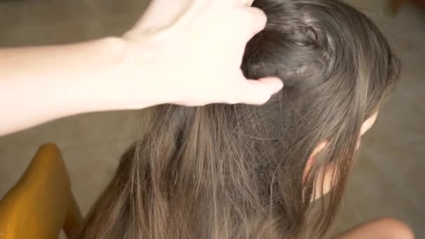クローズ アップ。4 k、スローモーション。女性の手では、茶色の髪の頭にシラミを発見します。しらみ症の治療. — ストック動画