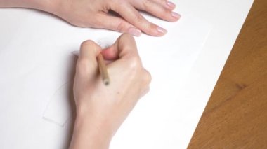 Ağır çekim. 4k, yakın çekim, en iyi görünüm. bir el bir kalemle çizer. bir kız elbise.