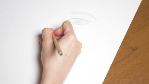 une main féminine dessine le portrait d'une fille. 4k, gros plan. Au ralenti. vue d'en haut .