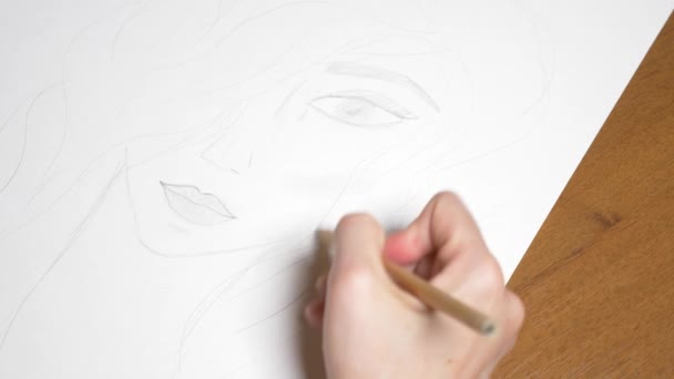 Eine weibliche Hand zeichnet das Porträt eines Mädchens. 4k, Nahaufnahme. Zeitlupe. Blick von oben. — Stockvideo