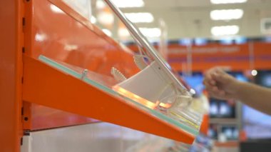 Alıcının elektronik mağazasında yeni bir gadget'ı seçer. 4k, yakın çekim, arka plan bulanıklık. Gadget'ı yeni bir barış için arıyorsunuz.
