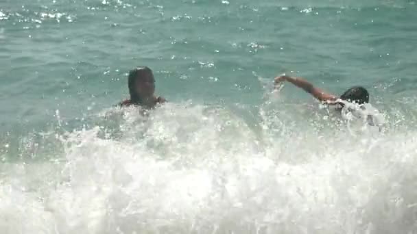 Szczęśliwe dzieci skaczą do fal morskich. 4k, zwolnionym tempie. — Wideo stockowe