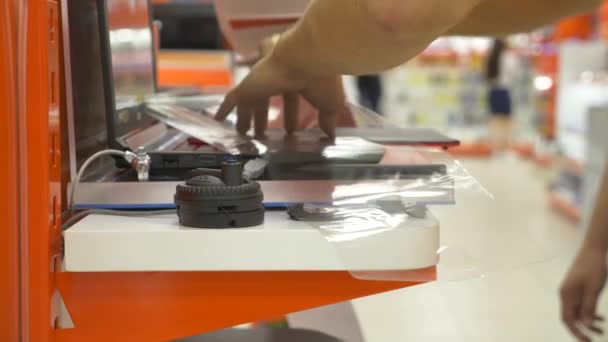 L'acheteur dans le magasin d'électronique choisit un nouveau gadget. 4k, gros plan, fond flou. Vous cherchez une nouvelle paix de gadget . — Video