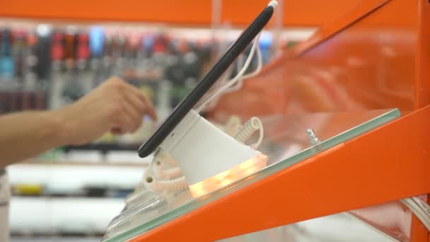 Alıcının elektronik mağazasında yeni bir gadget'ı seçer. 4k, yakın çekim, arka plan bulanıklık. Gadget'ı yeni bir barış için arıyorsunuz. — Stok video